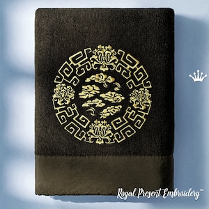 May include: A dark brown towel with a gold embroidered design of a circle with clouds and flowers. The towel has a dark brown border and the text "Royal Present Embroidery" is printed on the bottom.