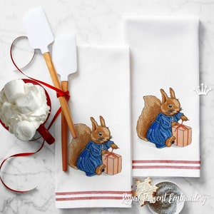 May include: Two white kitchen towels with red stripes feature an embroidered design of a brown squirrel wearing a blue outfit and holding a wrapped gift. The text "Royal Present Embroidery" is printed on the bottom of the towels.