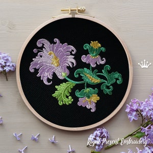 Puede incluir: Diseño floral bordado sobre tela negra en un aro de bordado de madera. El diseño presenta flores moradas, verdes y doradas.