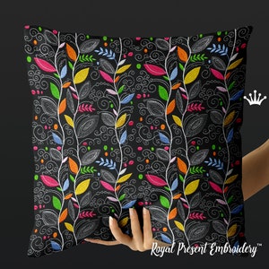 Könnte beinhalten: Ein schwarzes Kissen mit einem farbenfrohen Stickmuster. Die Stickerei zeigt weiße Ranken mit bunten Blättern und Schnörkeln. Das Kissen ist perfekt, um jedem Raum einen Hauch von Farbe und Verspieltheit zu verleihen.