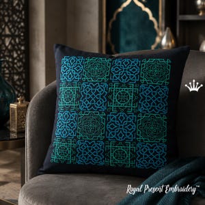 Op de afbeelding: Een vierkant zwart sierkussen met een raster van twaalf geborduurde geometrische patronen in blauwe en groenblauwe tinten. Het ontwerp bestaat uit complexe, herhalende knoopmotieven. Een klein wit kroonicoon en de tekst Royal Present Embroidery zijn zichtbaar.