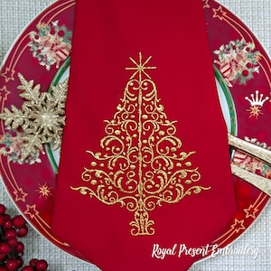 May include: A red fabric napkin with a gold embroidered Christmas tree design. The tree is decorated with swirls and a star at the top. The text "Royal Present Embroidery" is at the bottom of the napkin.