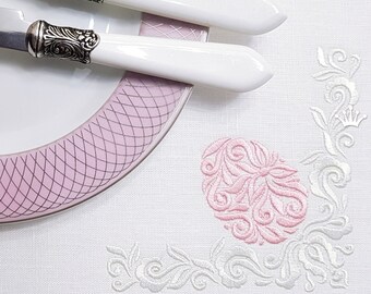 Peut inclure: Nappe en lin blanc avec un motif brodé rose et blanc. Le motif représente un grand œuf orné avec un motif floral. Le texte "Royal Present Embroidery" est visible dans le coin inférieur droit.