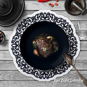 Puede incluir: Un camino de mesa de encaje blanco y negro con un plato negro y un filete cocinado encima. El plato está sobre una mesa de madera con un pequeño cuenco de salsa y un mortero y una maja en el fondo.
