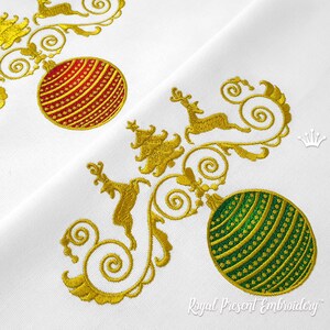 May include: Gold embroidered Christmas design featuring a red and green bauble, a stylised Christmas tree, and two reindeer. The design is on a white background.