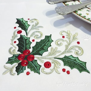 Puede incluir: Diseño de esquina bordado con hojas de acebo y bayas rojas con remolinos dorados sobre un fondo blanco.  "Royal Present Embroidery" está escrito en la esquina inferior derecha.