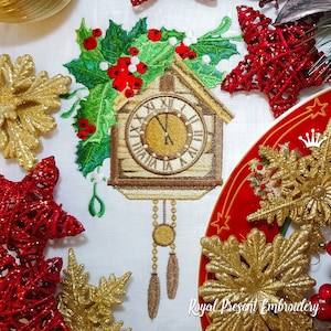 May include: Embroidered design of a cuckoo clock with holly and berries. The clock face is white with black Roman numerals and gold hands. The clock is brown with a white roof and is surrounded by green holly leaves and red berries.