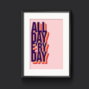 以下が含まれることがあります： ピンクの背景に「ALL DAY EVERY DAY」という文字が濃い紫で書かれた額装されたプリント。オレンジと黄色のグラデーションの影の効果が施されています。