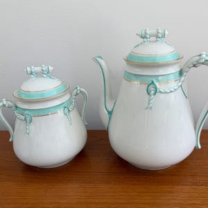 May include: A set of three ceramic mugs with a speckled, matte finish. The mugs are in shades of cream, light gray, and dark gray. Each mug has a simple, minimalist design, perfect for coffee or tea.