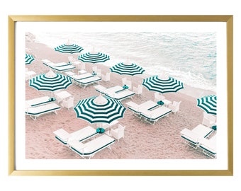 May include: A beach scene with white lounge chairs and striped green and white umbrellas on a sandy beach. The ocean is in the background.