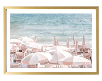 May include: A beach scene with pink and white striped umbrellas and white lounge chairs on a sandy beach with blue ocean water in the background.