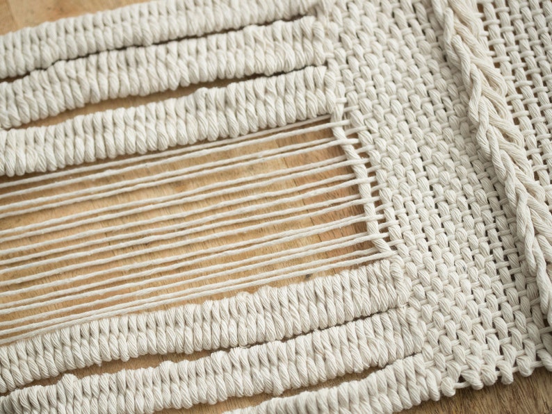 Detail shot of the meticulous weaving technique used in creating a Japandi-style cotton tapestry for unique wall decor.