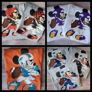 May include: Four different t-shirt designs featuring Mickey Mouse dressed as a football player. The shirts are in various colours, including orange, grey, and white. Each shirt features a different football team logo, including the Miami Dolphins, the Cincinnati Bengals, the Minnesota Vikings, and the New England Patriots.