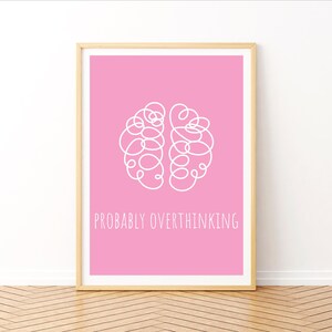 Puede incluir: Una impresión de arte de pared imprimible rosa con un contorno blanco de un cerebro y el texto "PROBABLY OVERTHINKING".