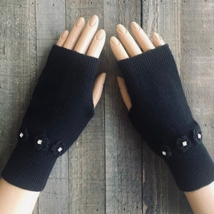 May include: Black fingerless gloves with white flower embellishments on the cuffs.