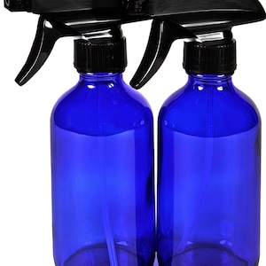May include: Two cobalt blue glass spray bottles with black trigger sprayers and black lids. The bottles are empty and ready to be filled with your favorite liquids.