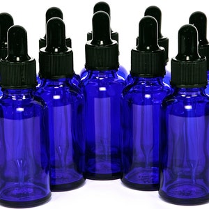 May include: Ten cobalt blue glass bottles with black dropper lids. The bottles are all the same size and shape, and they are arranged in a row.
