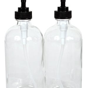 May include: Two clear glass bottles with black pump tops and white tubes. The bottles are empty and ready to be filled with liquid soap, lotion, or other liquids.