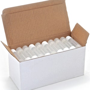 May include: A white cardboard box with the top open, revealing a full box of clear plastic tubes with white caps. The tubes are arranged in rows and are all the same size.