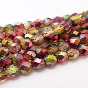 May include: Close-up of a strand of faceted beads in shades of red, purple, and gold. The beads have an iridescent finish, reflecting light. These beads are suitable for jewelry making and crafting projects.
