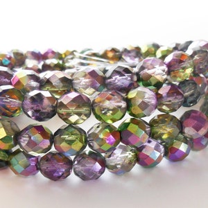 May include: Close-up of iridescent faceted beads in shades of purple, green, and gold. The beads are strung together, creating a shimmering effect. These beads are perfect for jewelry making and crafting projects.