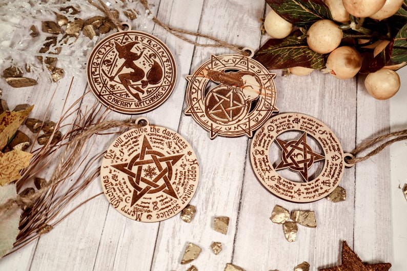 May include: Four wooden ornaments with a witch, pentagram, and solstice themes. The ornaments are decorated with intricate designs and text, including "Merry Witchmas" and "We will survive the darkness".