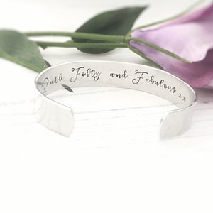 May include: Silver bangle bracelet with the inscription "Ruth Fifty and Fabulous xx" engraved on the outside.