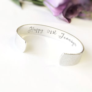 Op de afbeelding: Zilveren armband met de inscriptie "Happy 21st Jenavya" gegraveerd aan de binnenkant.