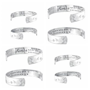 May include: Six silver bracelets with hammered metal surfaces. Each bracelet has a different inscription, including "Aunts like you are precious" and "Like you are precious & few".