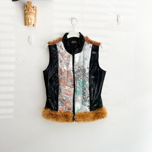 May include: A black sleeveless vest with a zipper closure and a brown faux fur trim. The vest has a white and black patterned design with a floral motif.
