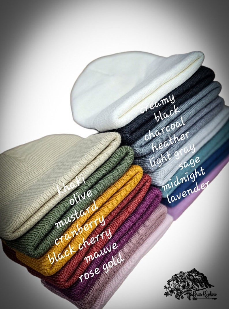 May include: A stack of 14 beanie hats in various colors, including olive, mustard, cranberry, black cherry, mauve, rose gold, creamy, black, charcoal, heather, light gray, sage, midnight, and lavender.