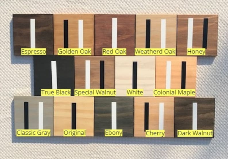 May include: A collection of fourteen square wooden samples arranged in three rows, each featuring a vertical stripe. The labels include Espresso, Golden Oak, Red Oak, Weatherd Oak, Honey, True Black, Special Walnut, White, Colonial Maple, Classic Gray, Original, Ebony, Cherry, and Dark Walnut.