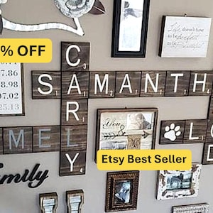 May include: A wall display featuring dark brown wooden tiles arranged like a crossword puzzle, spelling out names including Rich, Hamel, Carly, Samantha, Jarod, and Loki. The display incorporates framed photos, a paw print icon, and script text.