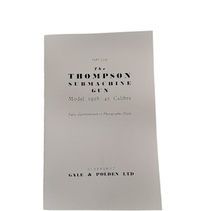 May include: A black and white book cover with the title "The Thompson Submachine Gun Model 1928 .45 Calibre" and the text "Fully illustrated with 17 Photographic Plates". The book is published by Gale & Polden Ltd. in Aldershot.