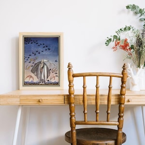 Peut inclure: Une impression d'art encadr&eacute;e pr&eacute;sentant une illustration vintage d'une figure en robe avec des oiseaux sur fond de ciel bleu. L'&oelig;uvre est dans un cadre en bois clair, expos&eacute;e sur un bureau en bois avec une chaise en bois. Des fleurs et de la verdure d&eacute;coratives sont dans un vase blanc.