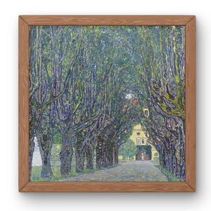 Puede incluir: Impresi&oacute;n enmarcada de una pintura que representa un camino bordeado de &aacute;rboles que conduce a un edificio amarillo. La obra de arte presenta un dosel de hojas y ramas verdes, con un marco de madera marr&oacute;n claro.