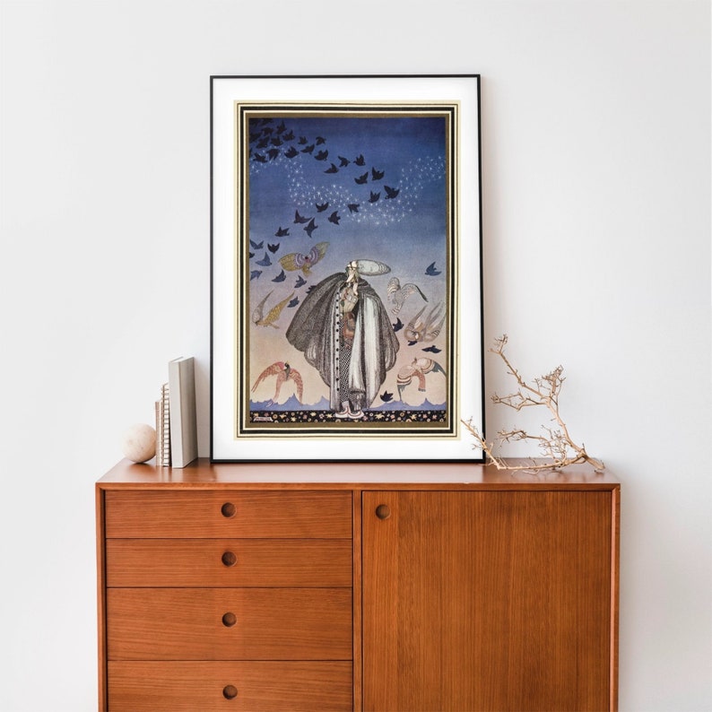 Peut inclure: Impression d'art encadr&eacute;e repr&eacute;sentant une figure en manteau long entour&eacute;e d'oiseaux. L'&oelig;uvre d'art pr&eacute;sente un sch&eacute;ma de couleurs bleu et or, avec un cadre noir et un passe-partout blanc. L'impression est expos&eacute;e sur un meuble en bois.