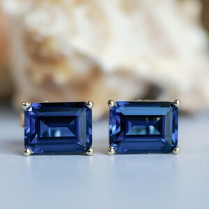 Puede incluir: Un par de pendientes de zafiro azul con un corte rectangular esmeralda. Los pendientes est&aacute;n engastados en oro.