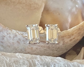 Könnte beinhalten: Ein Paar Diamant-Ohrringe im Smaragdschliff, gefasst in Silber.