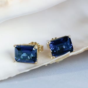 Puede incluir: Un par de pendientes de oro con piedras preciosas rectangulares azules.