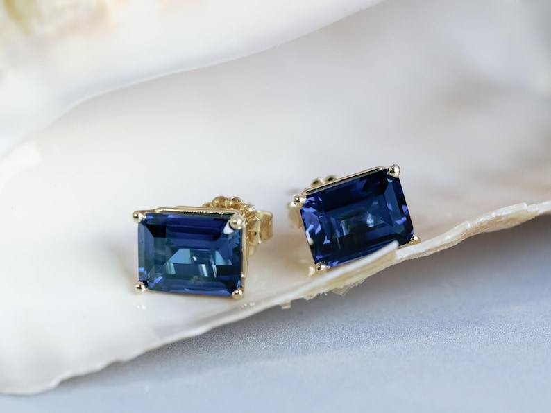 Puede incluir: Un par de pendientes de oro con piedras preciosas rectangulares azules.