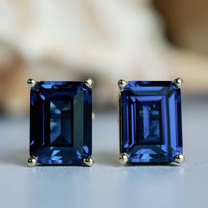 Puede incluir: Un par de pendientes de oro con piedras preciosas azules de talla esmeralda.