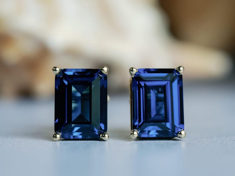 Puede incluir: Un par de pendientes de oro con piedras preciosas azules de talla esmeralda.