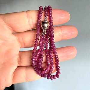 Può includere: Una collana a tre fili composta da perle di rubino sfaccettate con una chiusura magnetica in argento.