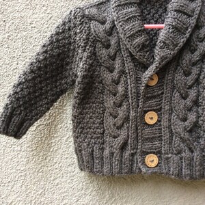グレーのニットベビーカーディガン、男の子用ケーブルセーター、手編みの冬用コート、帰宅時の服装、ベビーニットウェア、誕生日プレゼント、写真小道具コート