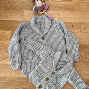 グレーのニットベビーカーディガン、男の子用ケーブルセーター、手編みの冬用コート、帰宅時の服装、ベビーニットウェア、誕生日プレゼント、写真小道具コート