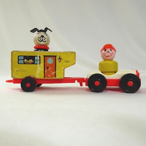 May include: A vintage Fisher-Price toy set featuring a yellow camper trailer with a dog figure and a red and white car with a figure. The camper has a red door and black wheels. The car has black wheels and a red base.
