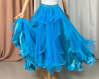 Peut inclure: Une jupe en tulle turquoise à plusieurs couches avec une doublure en satin. La jupe est présentée sur un mannequin blanc avec des bras en bois.