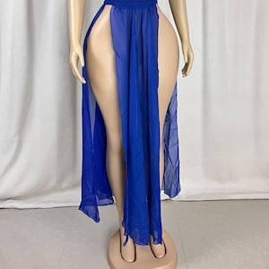 Puede incluir: Una falda maxi de gasa azul real con cintura alta y dos aberturas a los lados.