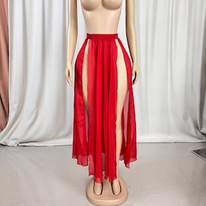 Puede incluir: Una falda larga de gasa roja con dos aberturas altas en la parte delantera. La falda est&aacute; en un maniqu&iacute;.